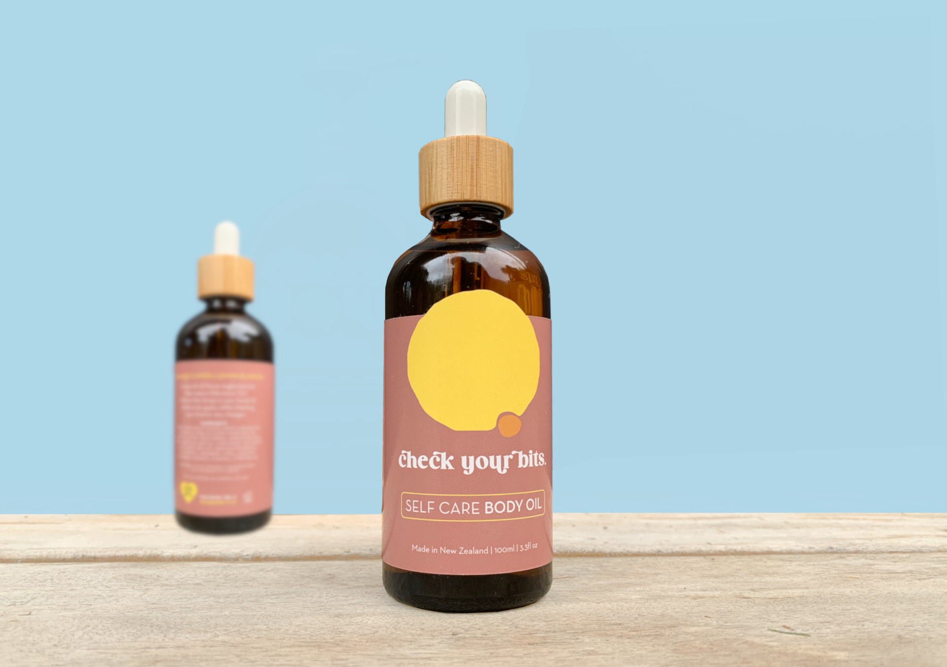 Close-up of the Check Your Bits self care body oil dropper bottle
